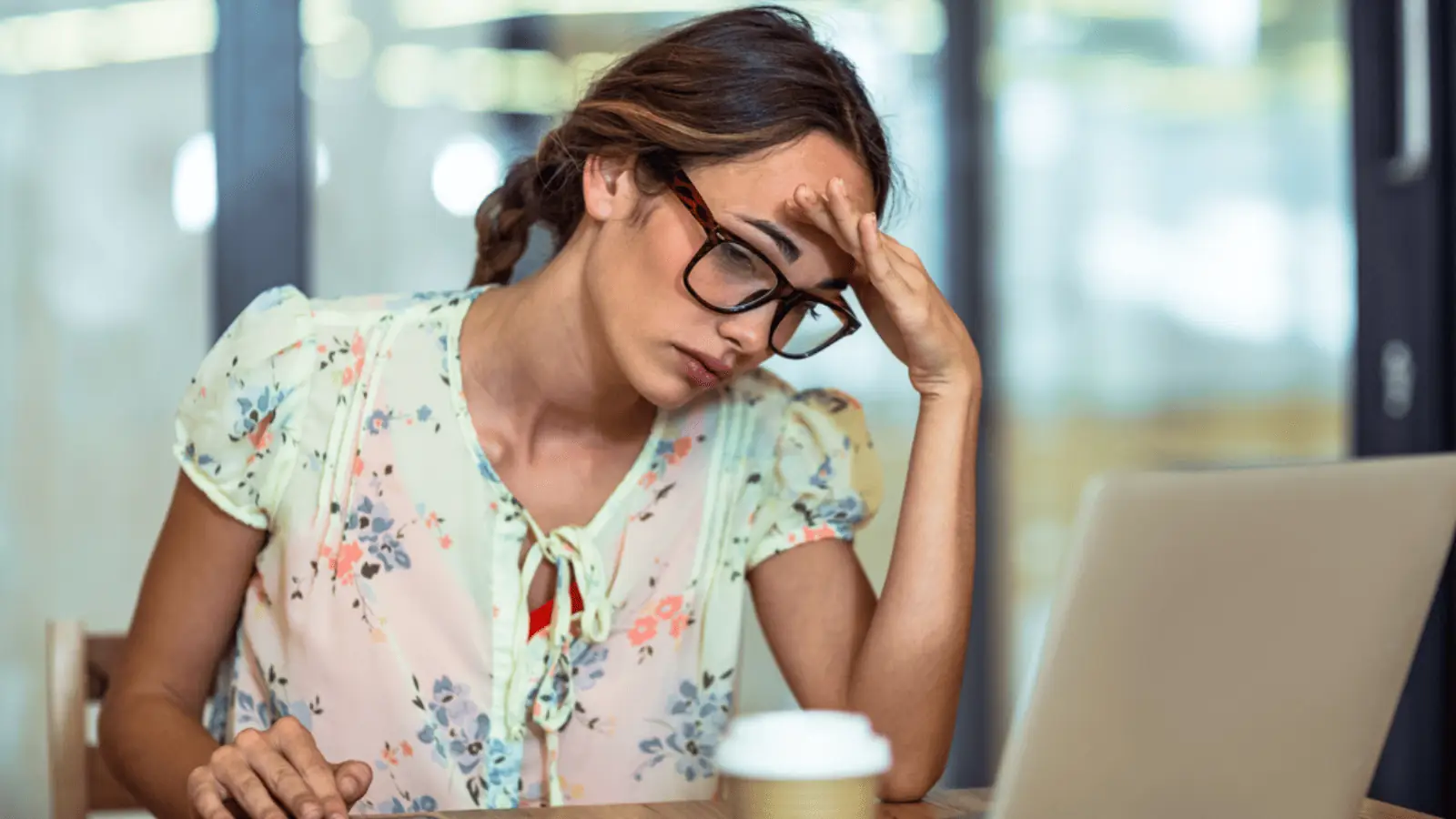 frustrated woman at her computer coffee glasses headache