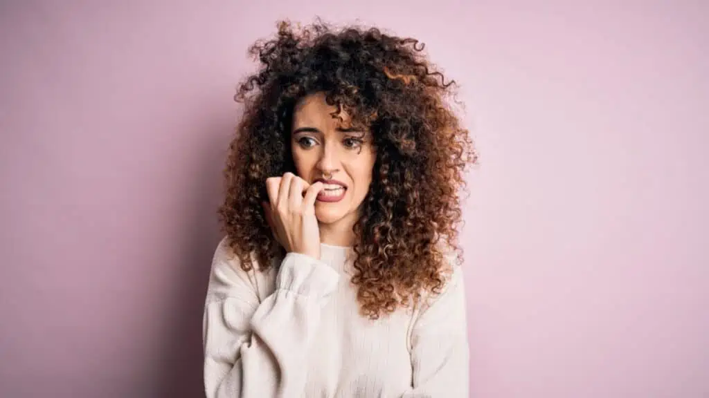 Woman biting her finger wearing pink