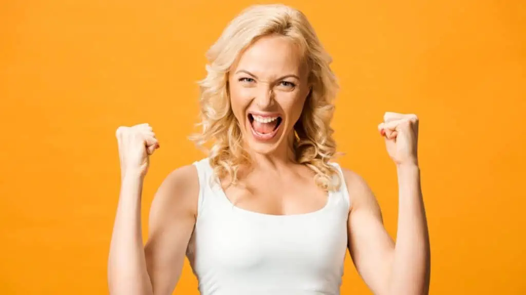 A woman celebrates her triumph as a winner in orange