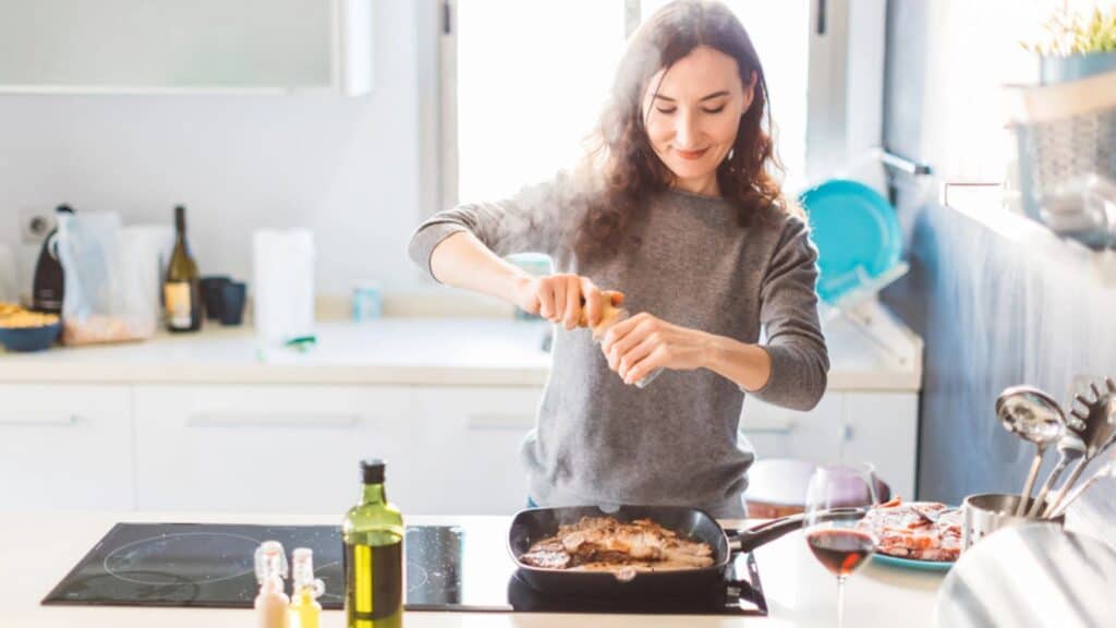 Woman cooking and grilled meat at home