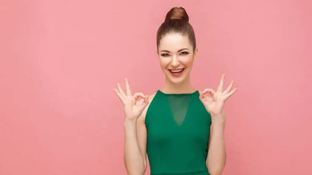 Woman showing ok signs on pink