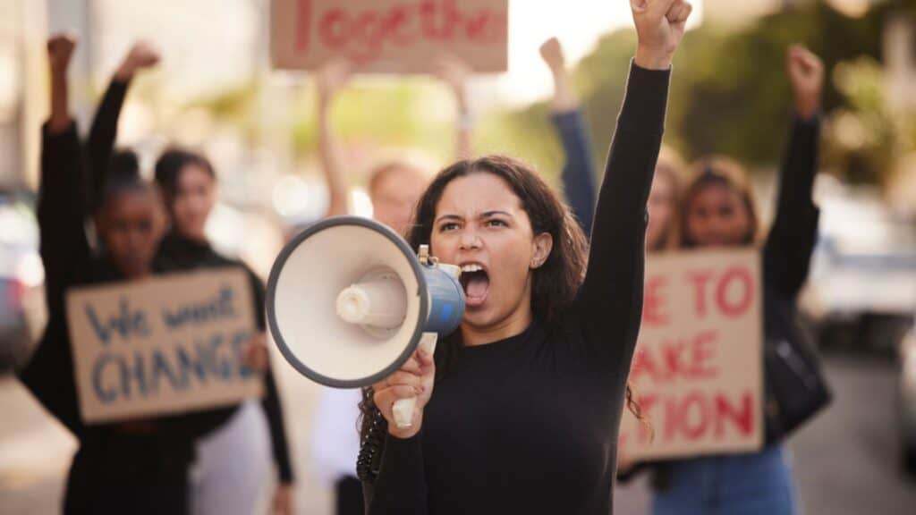 Woman using megaphone and fist in community protest for change