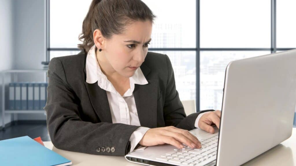 Woman wearing business suit working on laptop computer at office