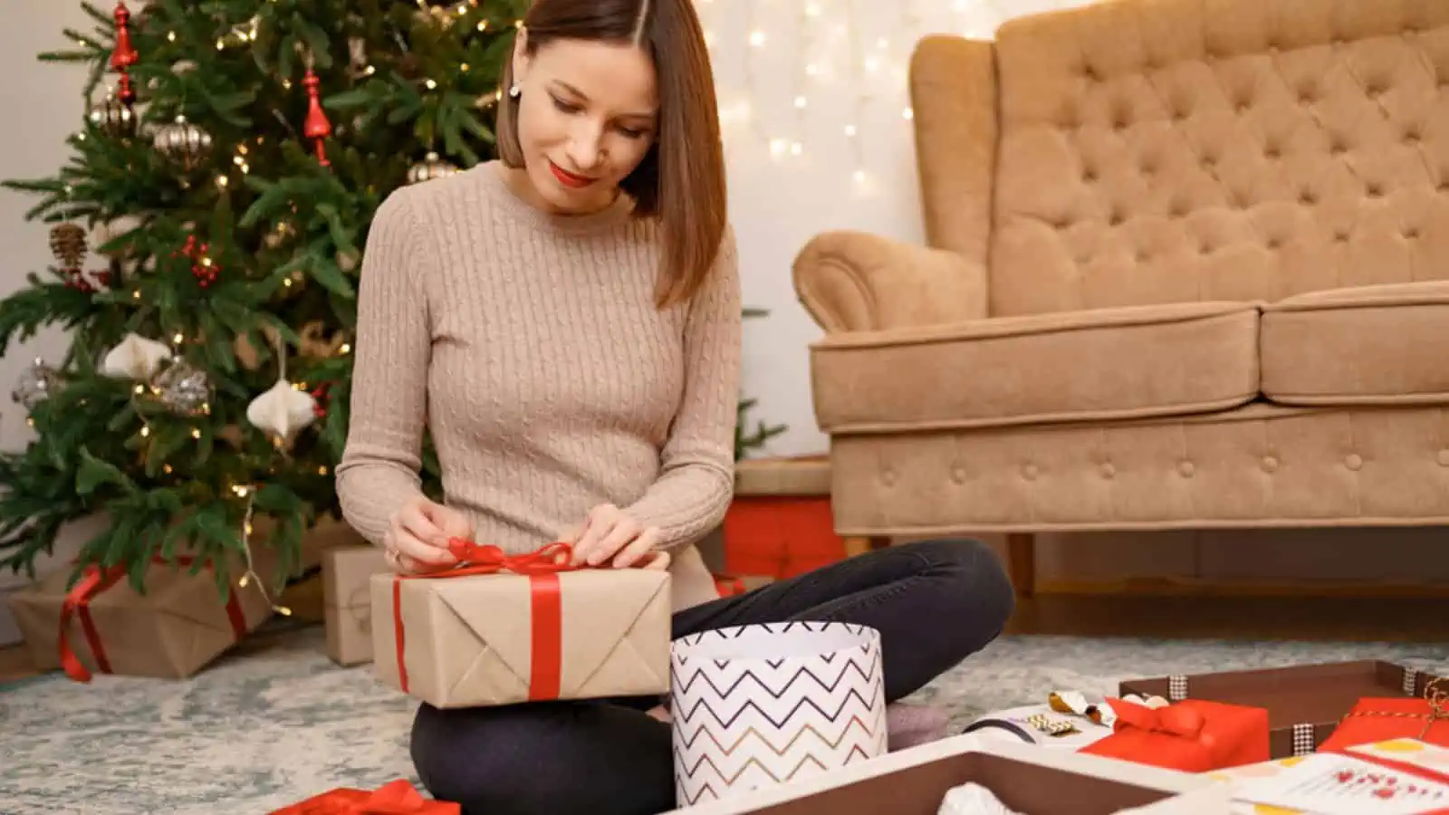 Woman wrapping Christmas gifts presents at home