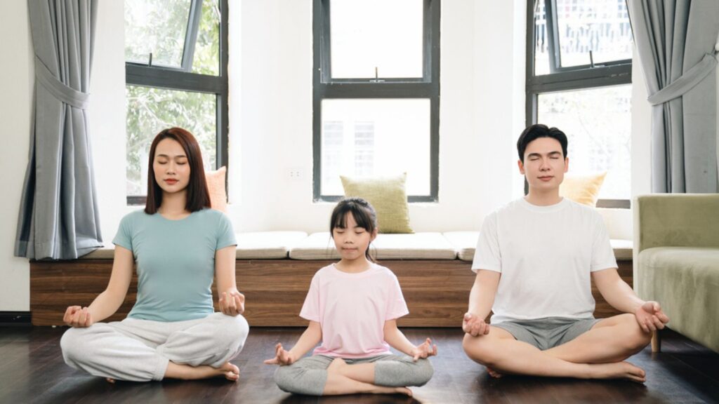 Young Asian family exercise yoga at home