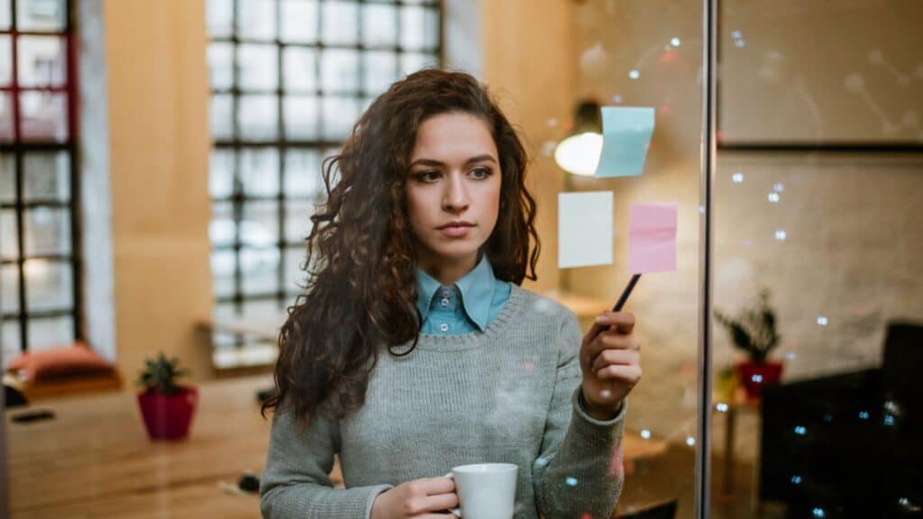 Young businesswoman making business plans and drinking coffee in her house