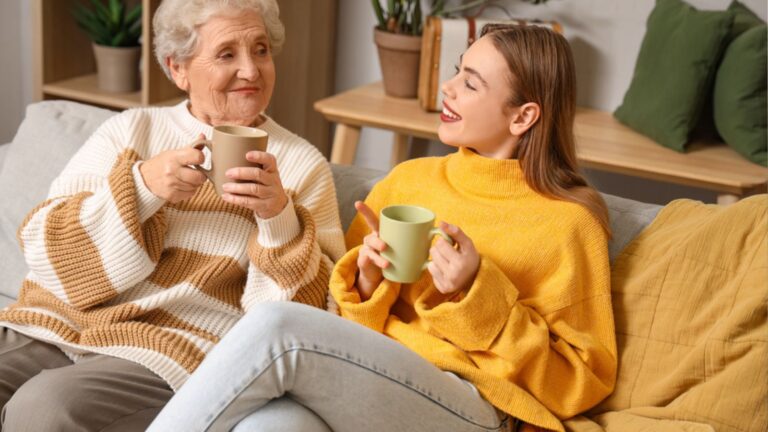 Young woman and her grandmother drinking tea at home