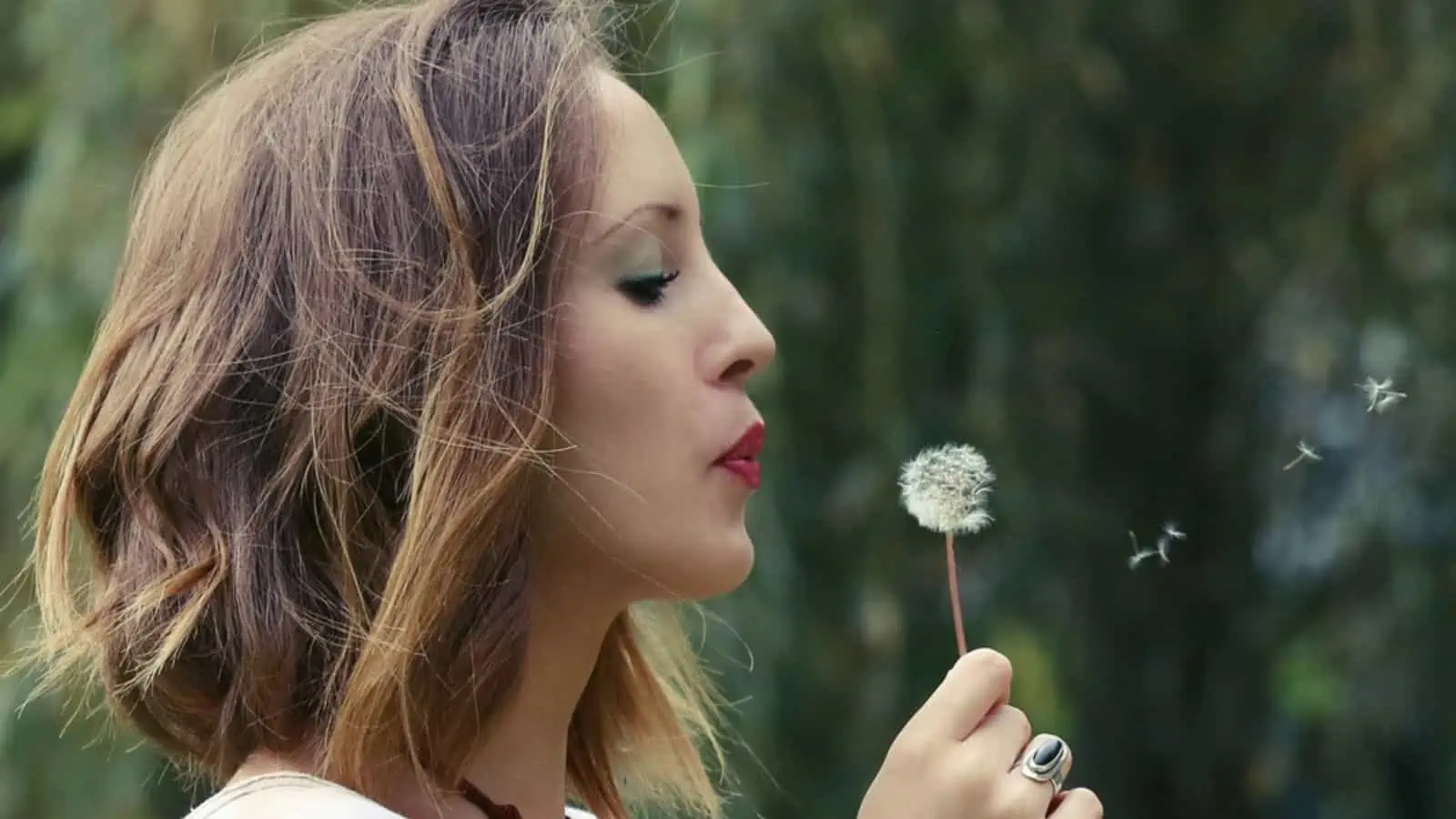 Young woman with dandelion