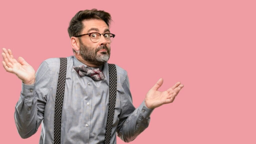 confused man hands up glasses suspenders