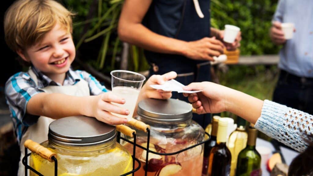 little boy selling lemonade for money