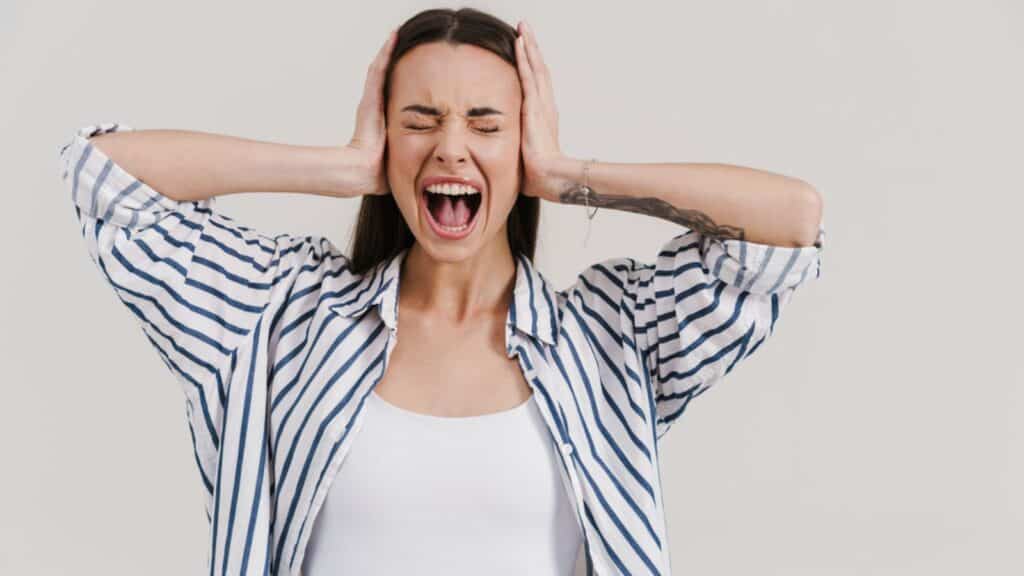 frustrated woman yelling covering her ears