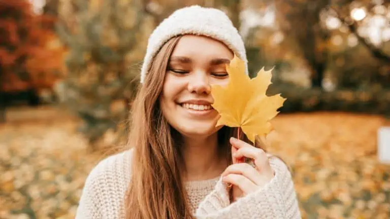 woman holding a leaf fall autumn hat