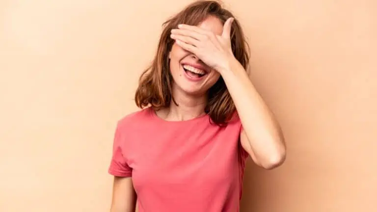 laughing woman hiding her face embarrassed