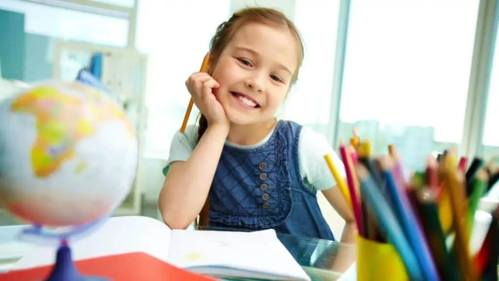 girl at school earning colored pencils globe