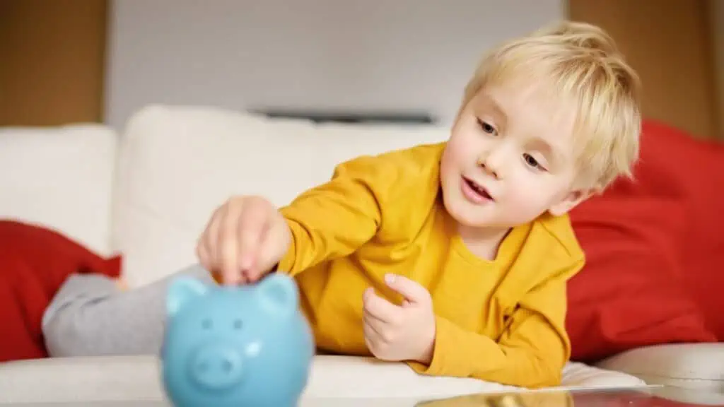 child with a blue piggy bank saving boy