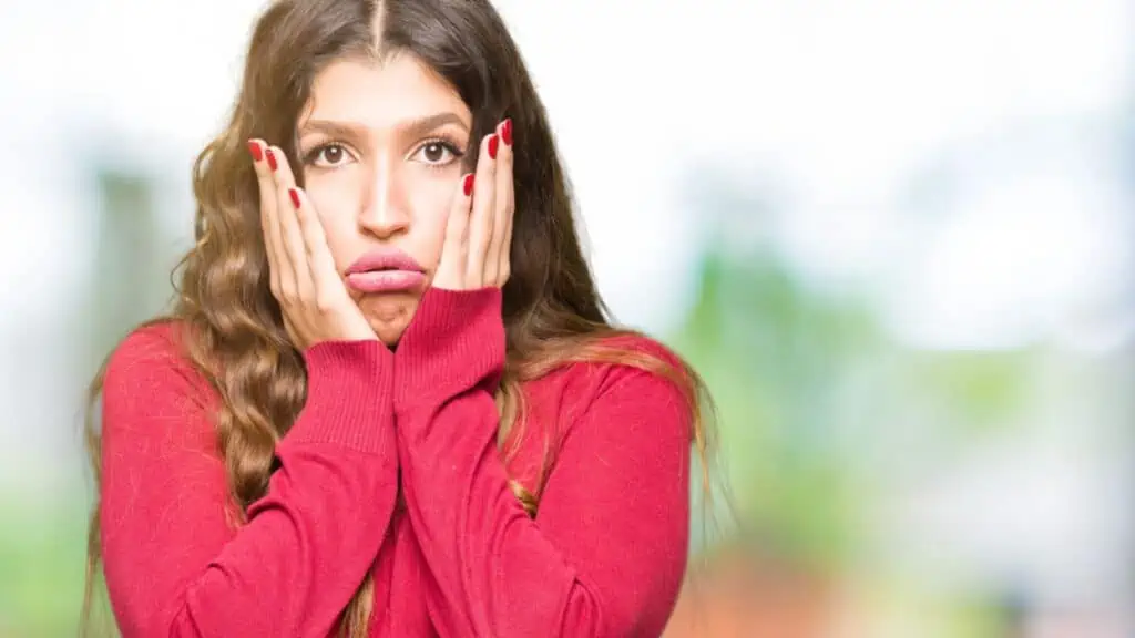 frustrated woman hands on face