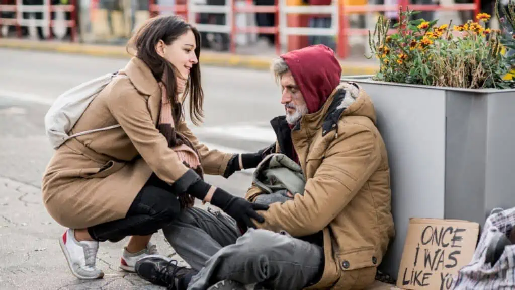 homeless man with a woman comforting cold