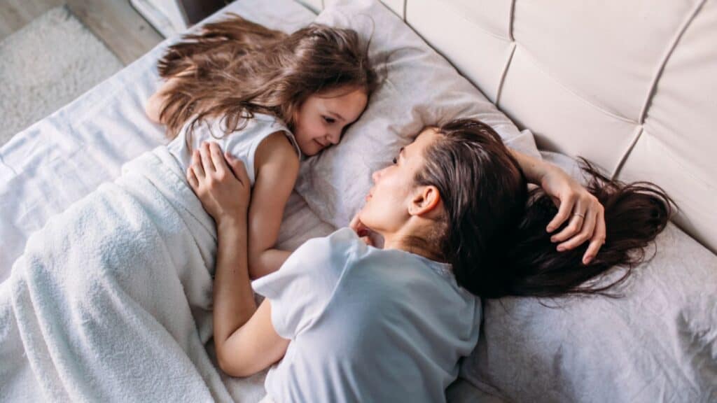 mom and daughter love bed snuggle happy