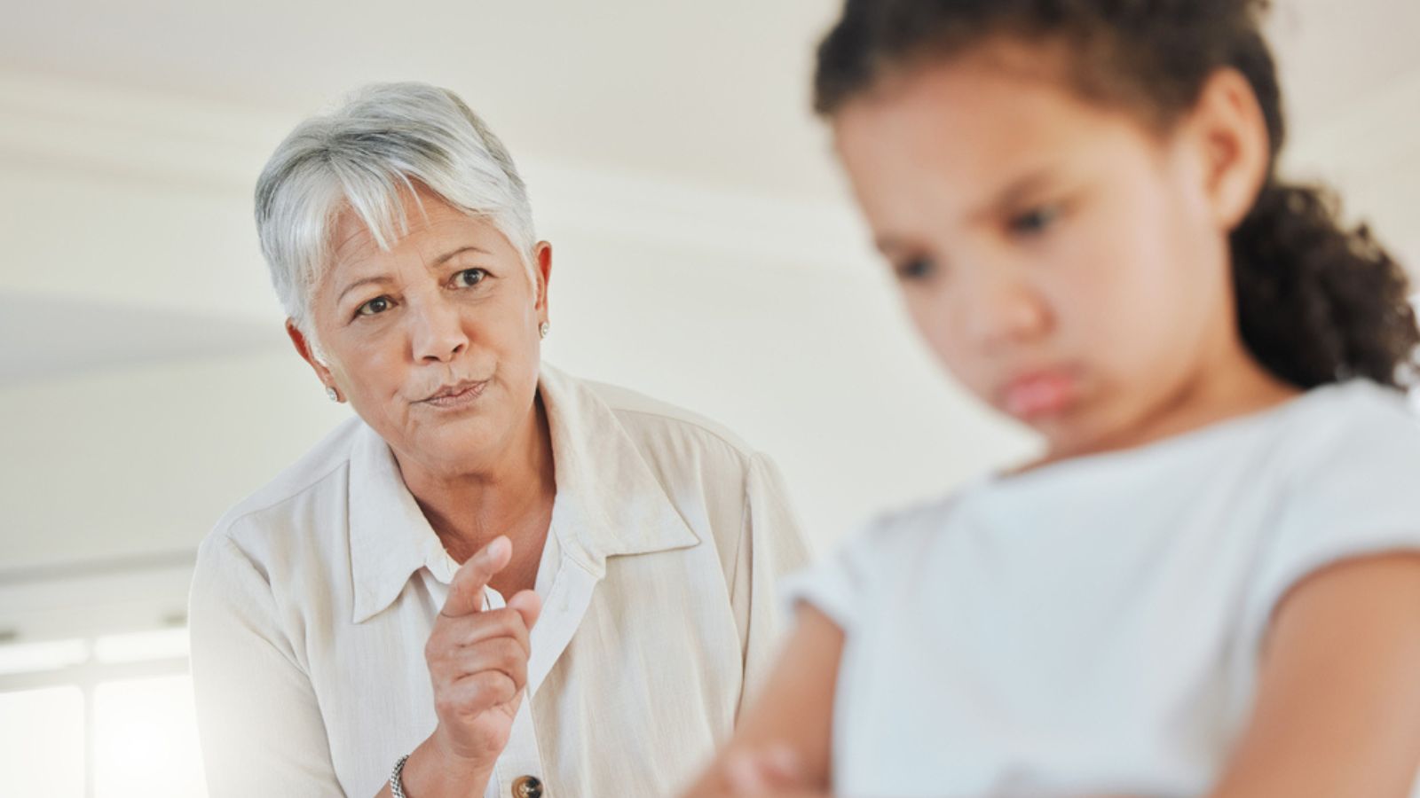 grandmother looking annoyed with her granddaughter at home