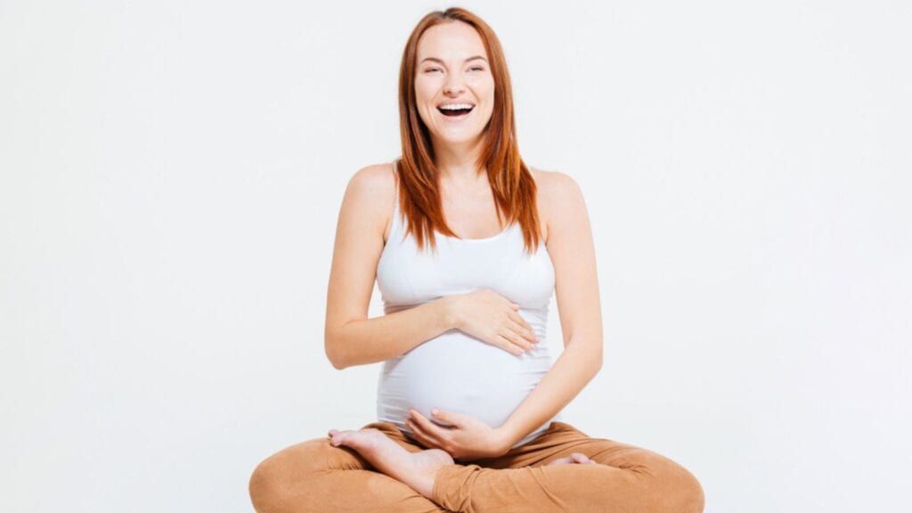 laughing pregnant woman in white