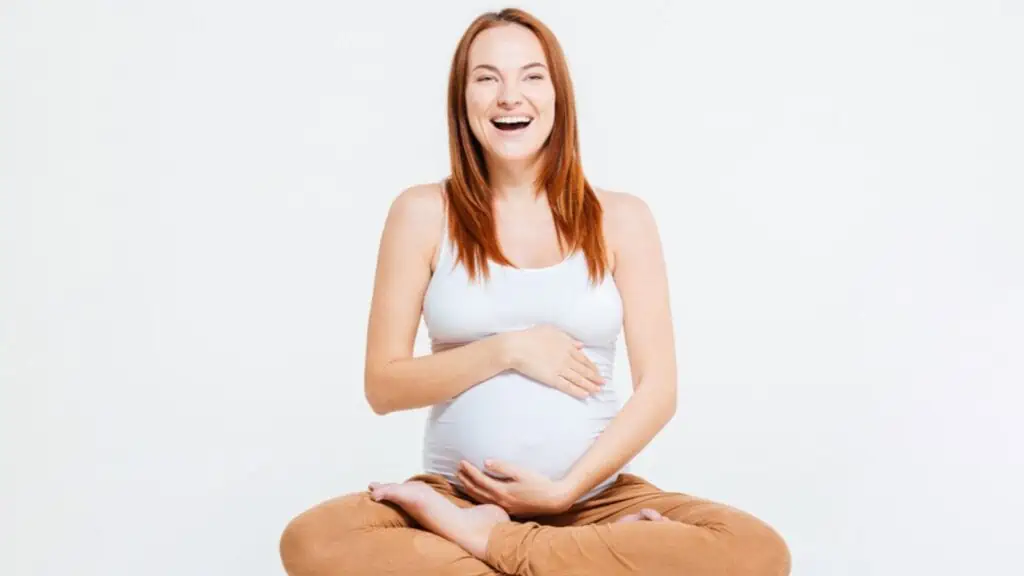 laughing pregnant woman in white