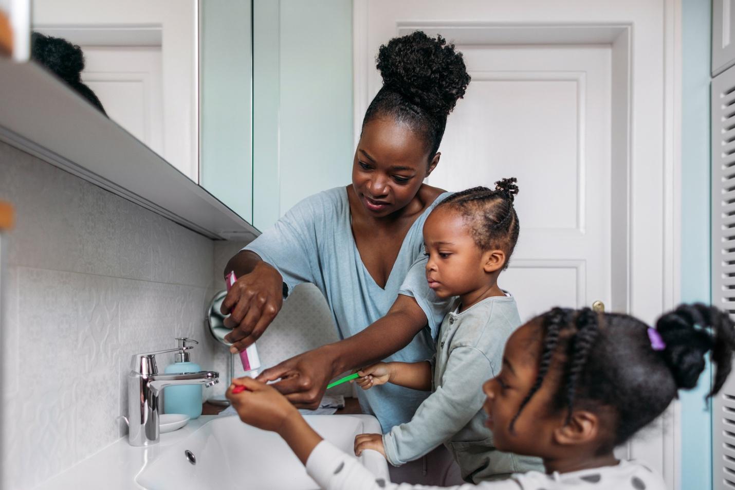 kids and mom in the bathroom brushing teeth
