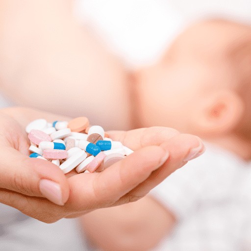 woman holding medication while breastfeeding